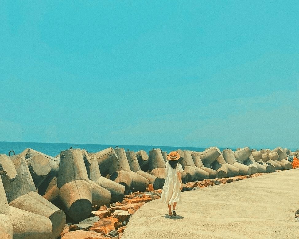 Du khách check-in trên con kè chắn sóng Bãi đá Ông Địa