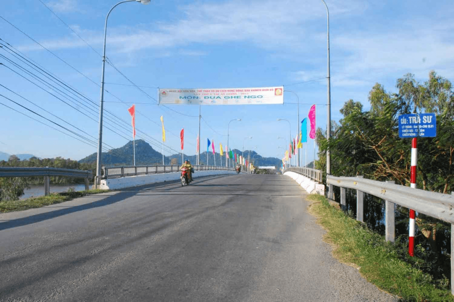 Cầu Trà Sư rực rỡ cờ hoa dẫn lối vào khu du lịch rừng tràm An Giang
