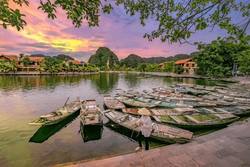 Bến thuyền Tam Cốc Ninh Bình lúc hoàng hôn tím hồng bên bờ sông