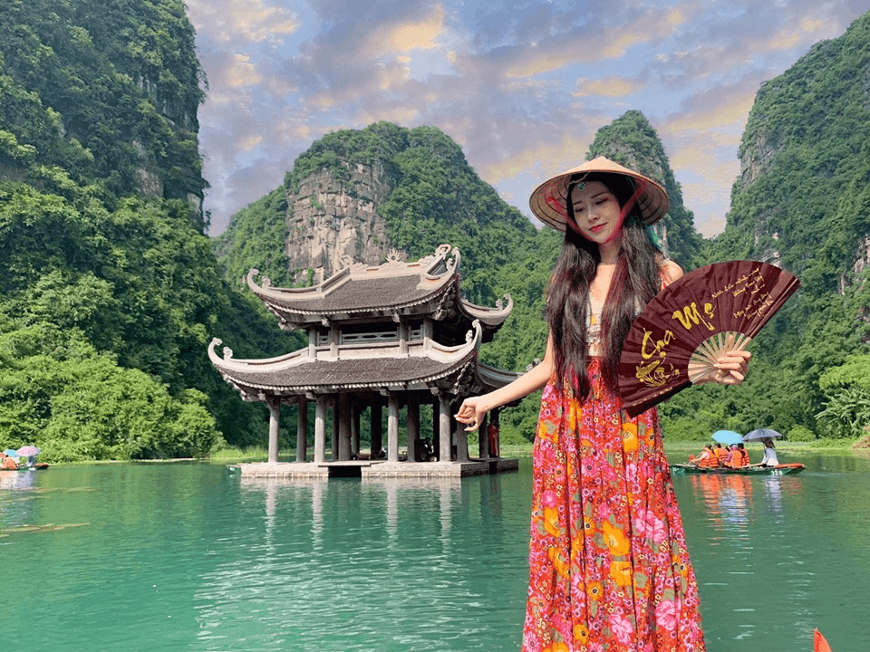 Du khách mặc váy hoa đội nón lá check in Thủy Đình Tràng An