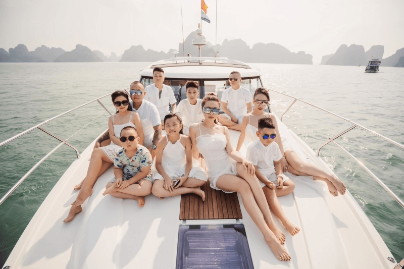 Gia đình mặc trang phục trắng check in boong du thuyền vịnh Hạ Long
