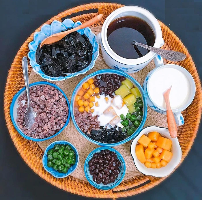 Mẹt tre bày biện đa dạng các món chè ngọt thanh mát gồm sương sáo, đậu đỏ, khoai dẻo và trân châu ngũ sắc, rưới thêm nước cốt dừa thơm béo.