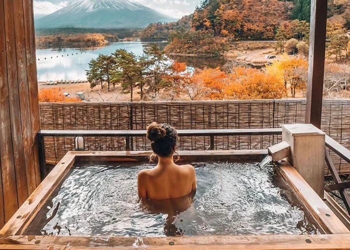 Du khách tắm suối nước nóng onsen ngắm núi Phú Sĩ giữa rừng lá thu